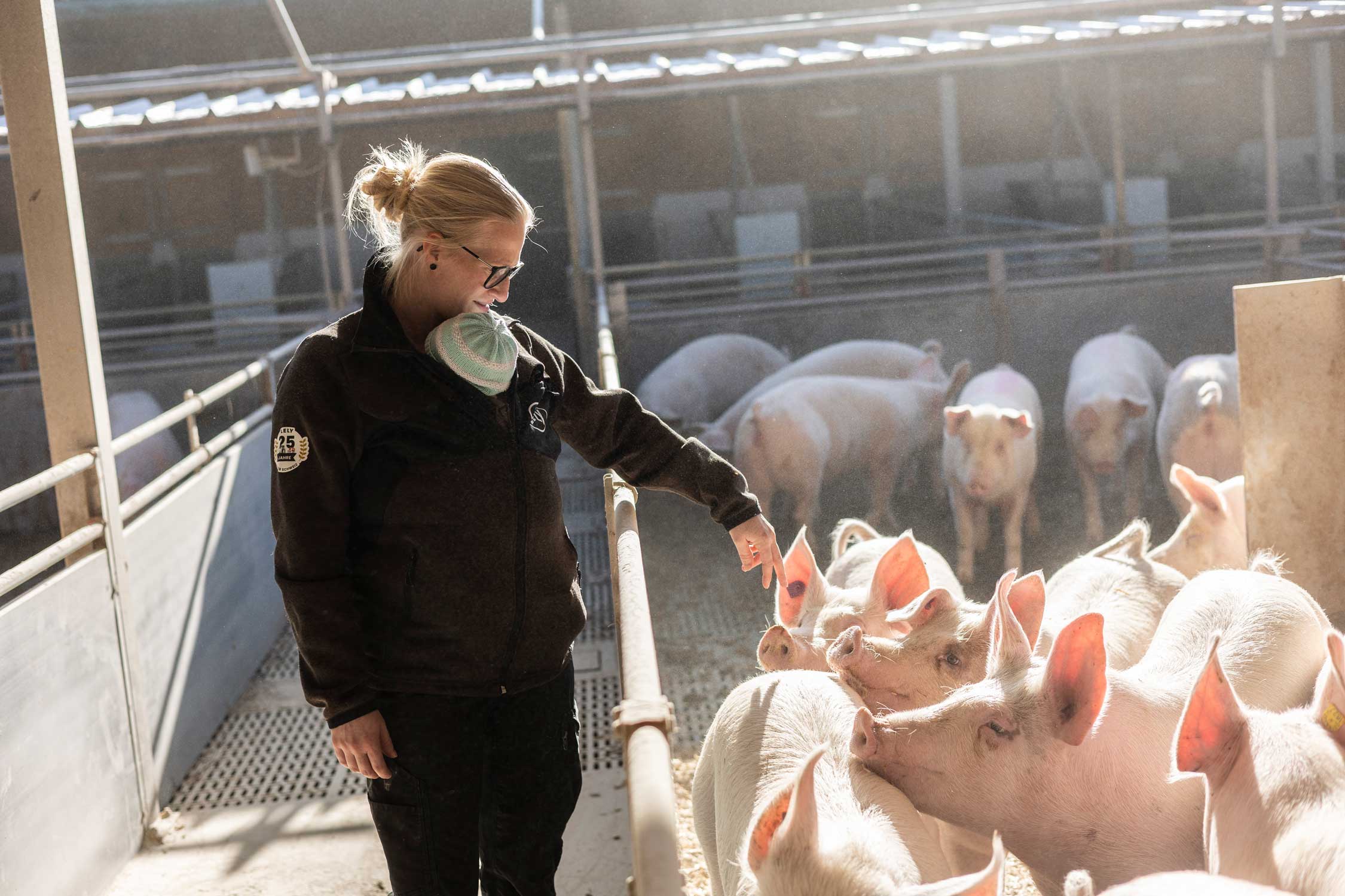 Manuela Bigler mit ihrem Kind im Schweinestall.