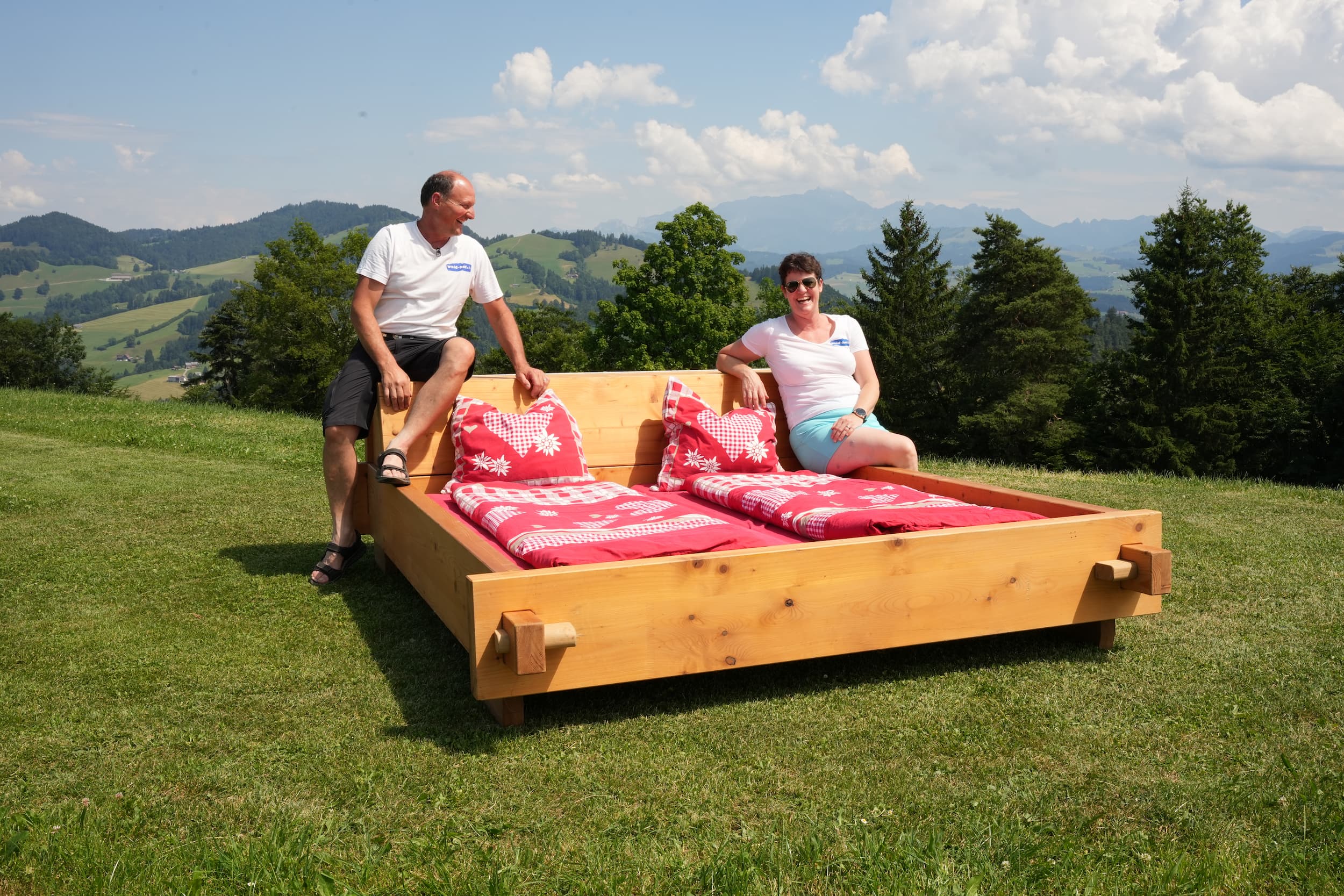 Familie Roth sitzt auf einem Bett mitten auf der Weide.