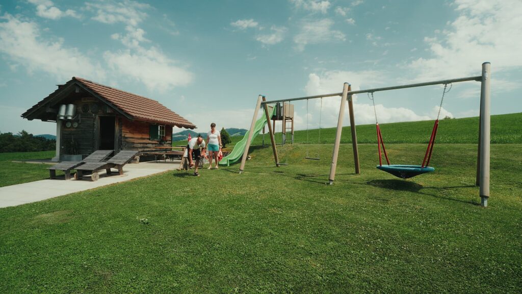 Ein Spielplatz mit Schaukel und Rutschbahn.